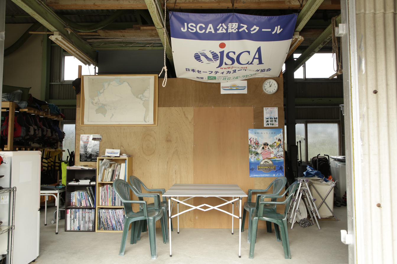 カヤックスクールの施設を写した写真。JSCA公認スクールである事を表すタペストリーなどが飾られている。