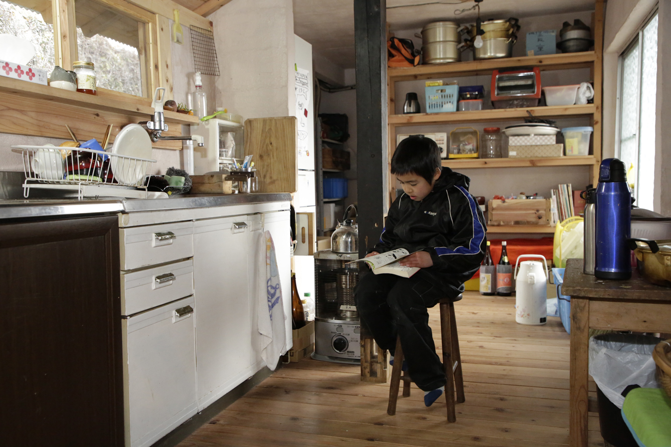 リフォーム後の台所の様子。谷川原さんのお子さんが椅子に座って本を読んでいる。