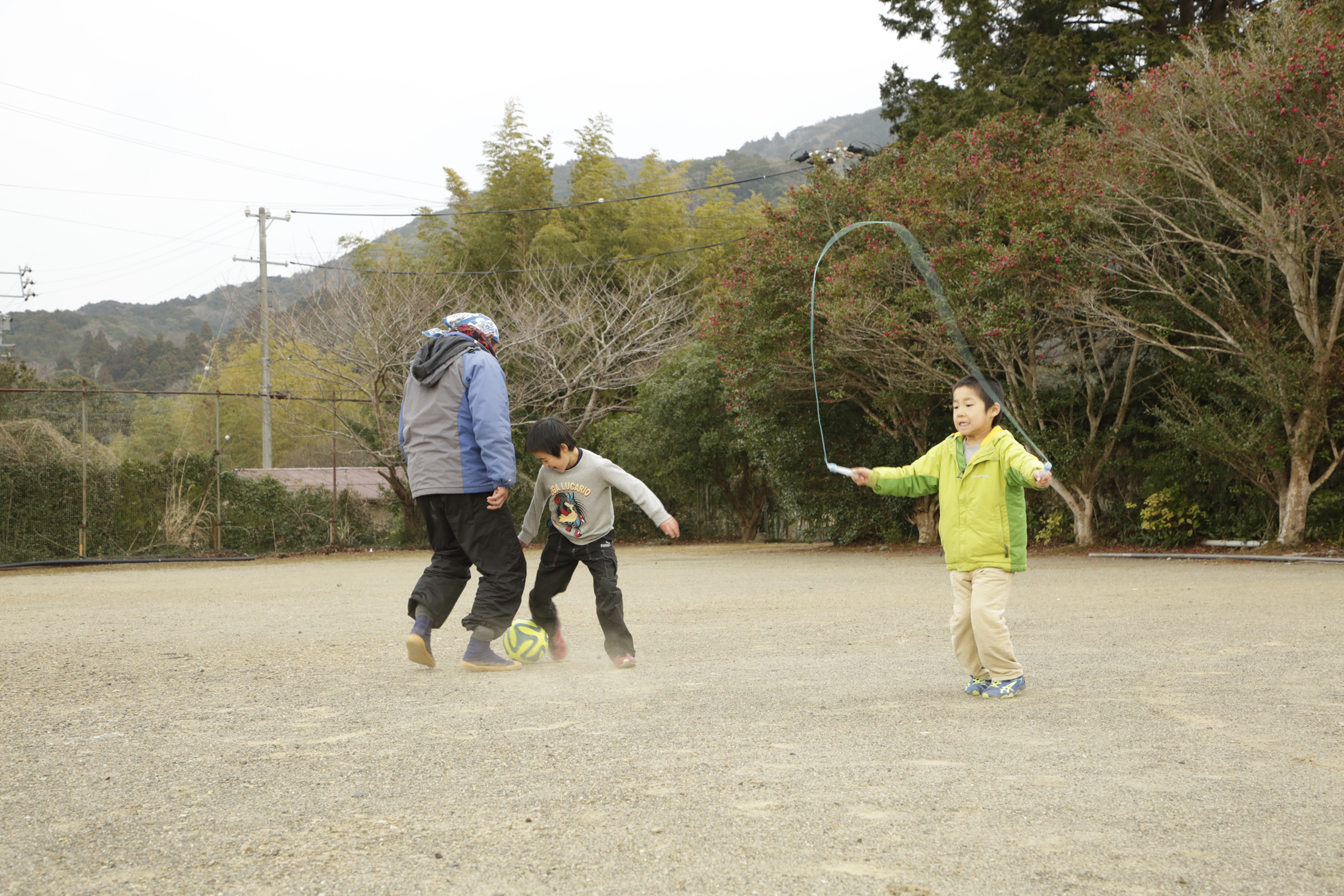 広場で遊んでいる谷川原さんと子供たちの様子を写した写真。